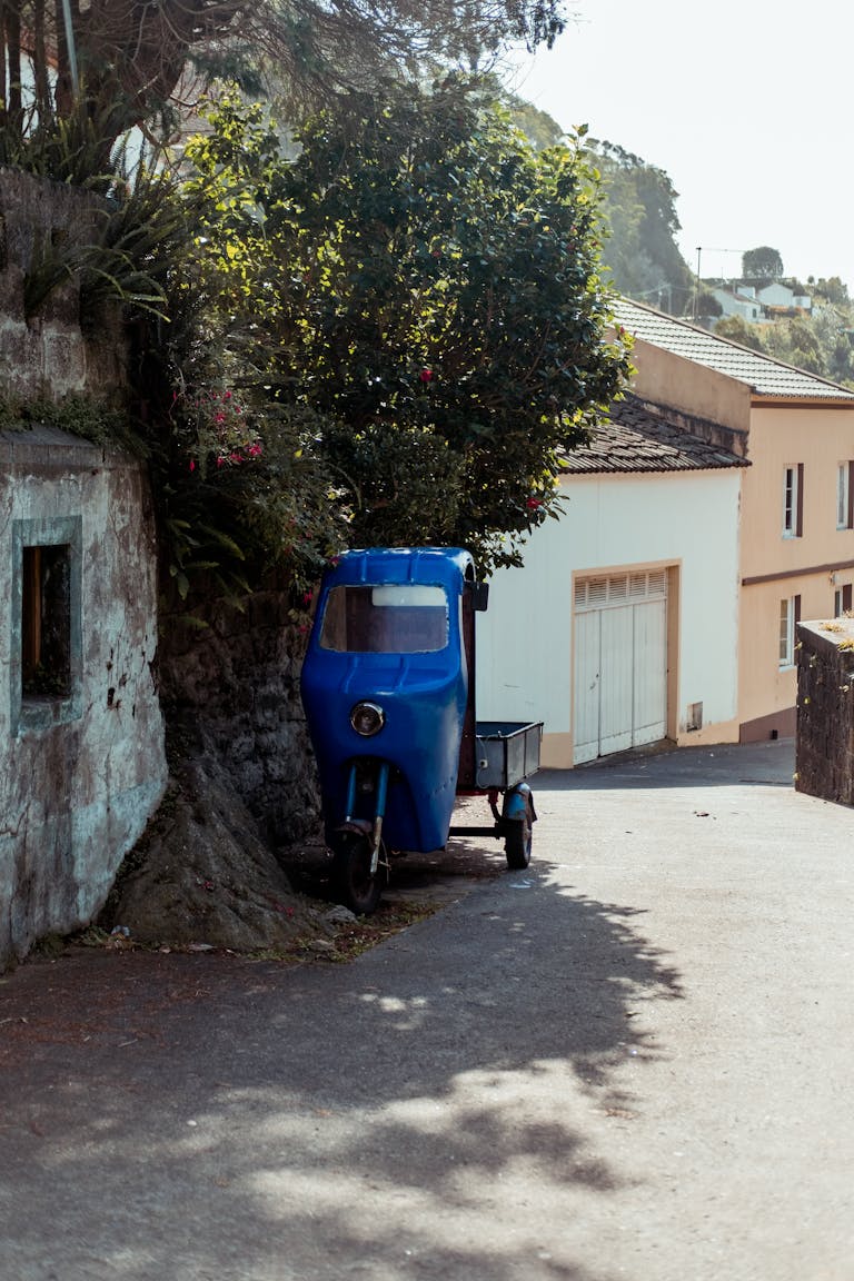 A vibrant blue motorcycle parked on a charming street in Agua de Alto, Azores.